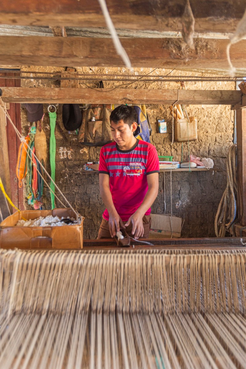 A weaver at a wooden foot loom in Momostenango, Guatemala